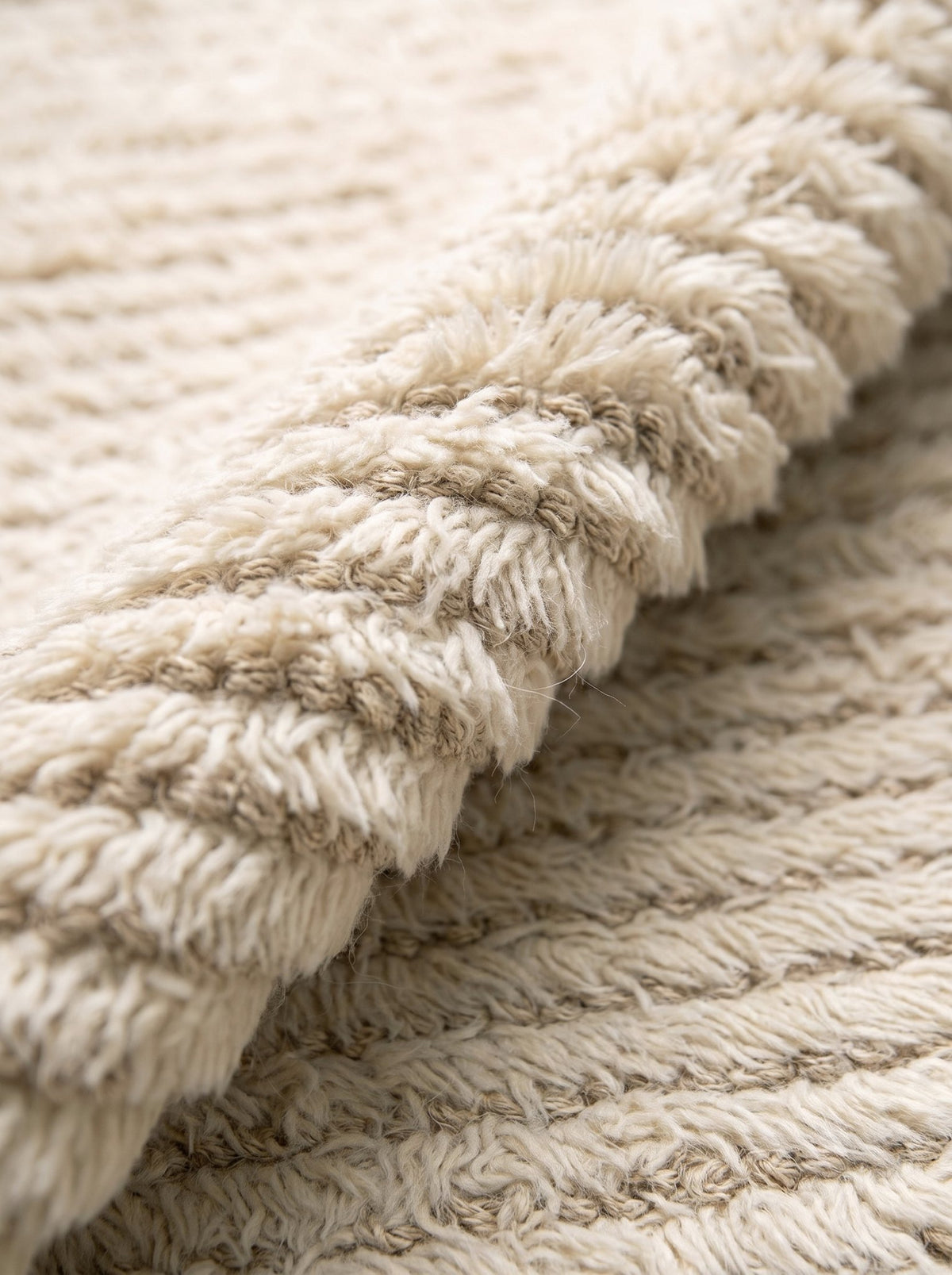 Article 411 ivory ribbed texture alpaca and linen handwoven rug folded back to show pile depth and texture
