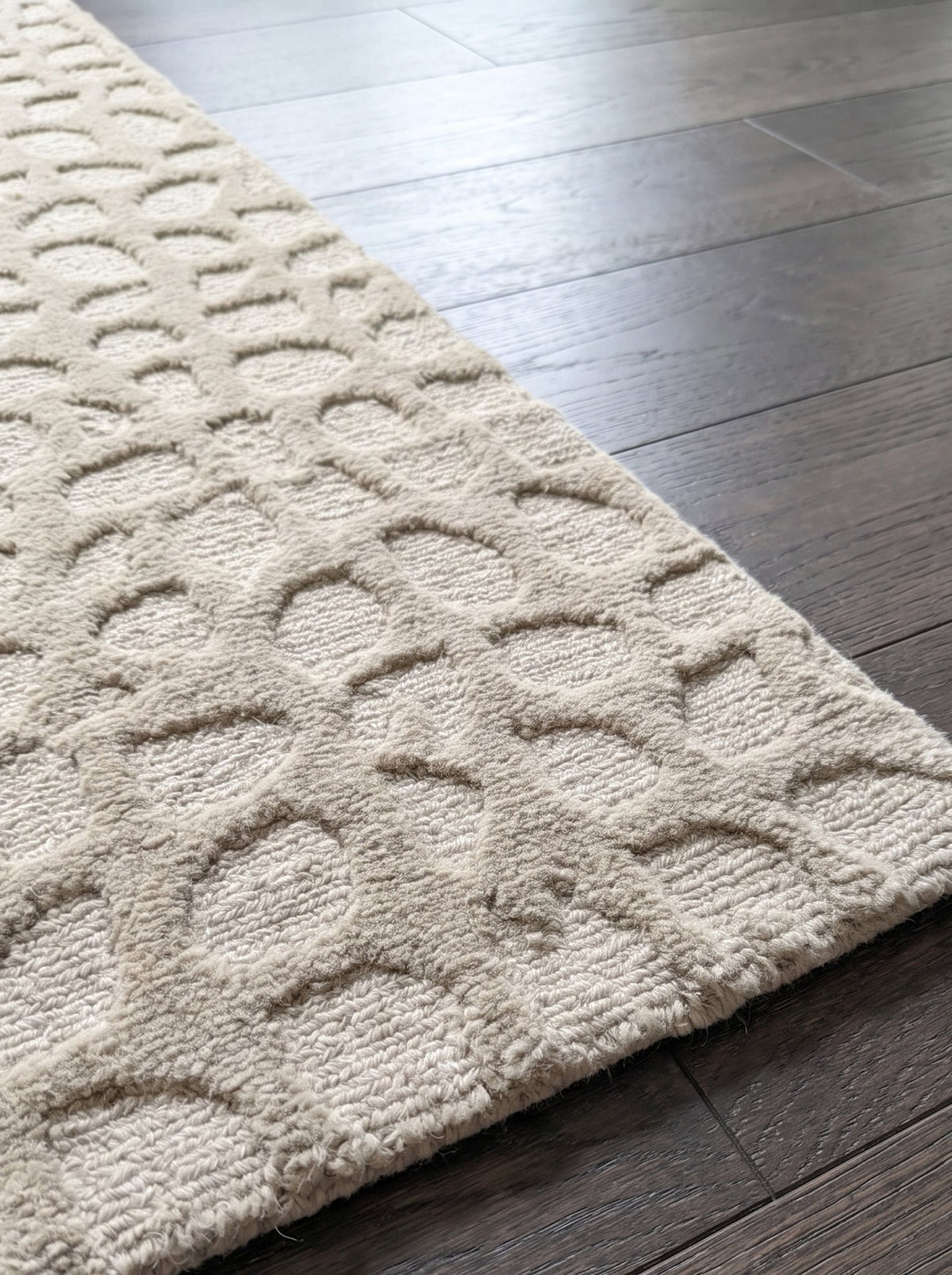 Corner of the Article 442 ivory pebble alpaca hand-knotted rug showing the pile and finished edge