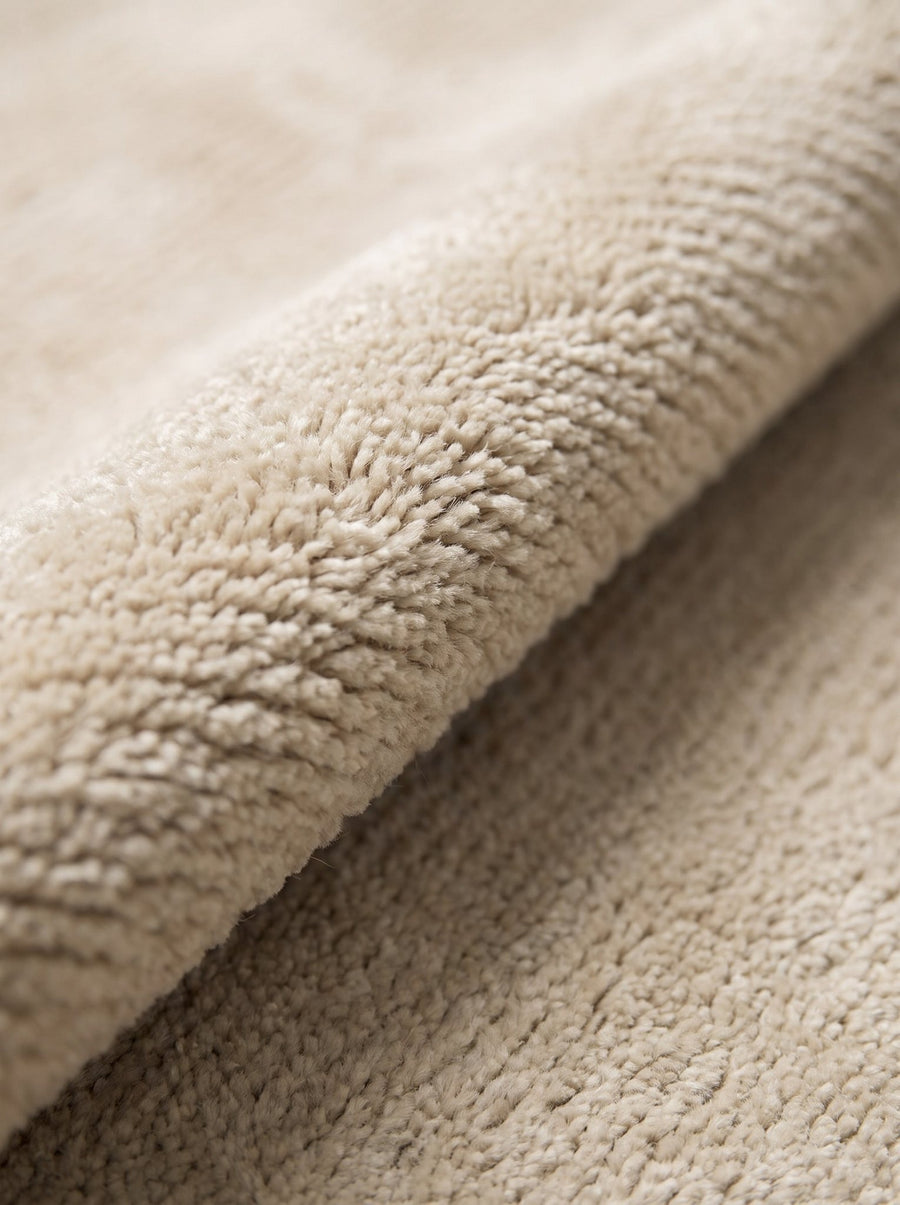 Article 611 ivory solid cashmere handwoven rug folded back to show pile depth and texture