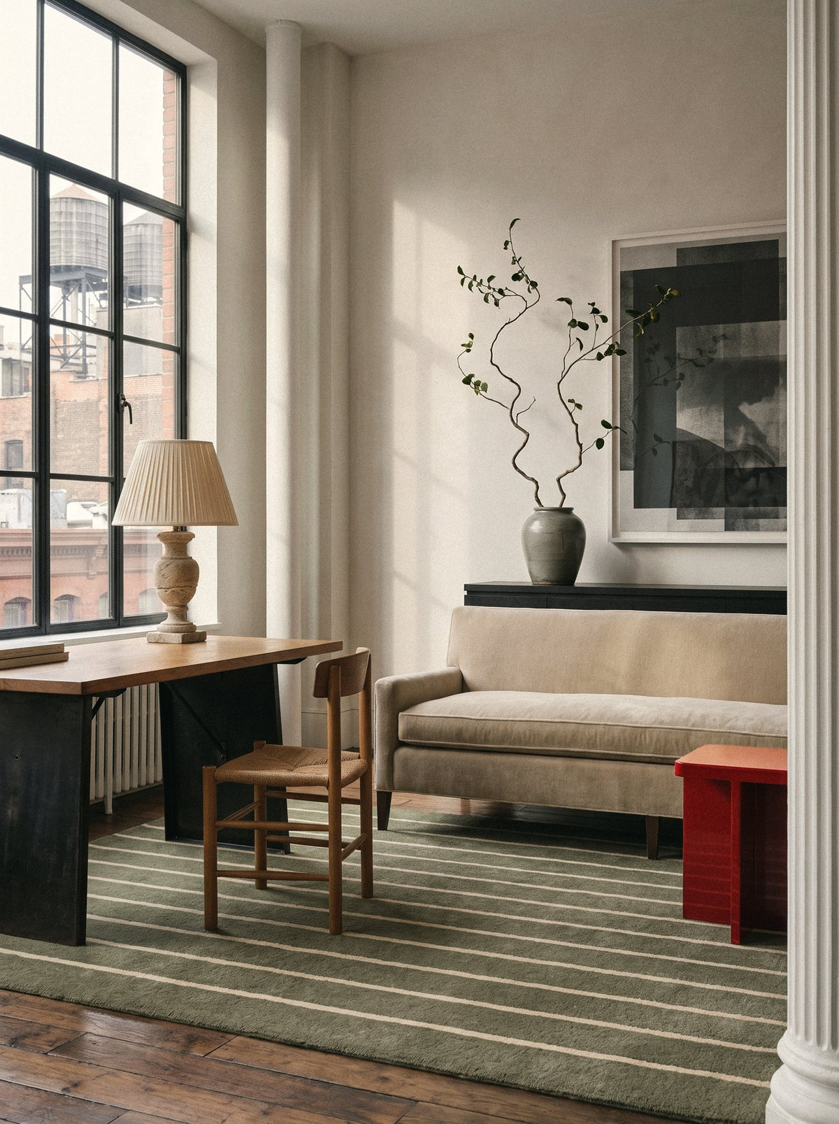 Article 221 olive pinstripe merino wool and cashmere hand-loomed rug in a loft corner