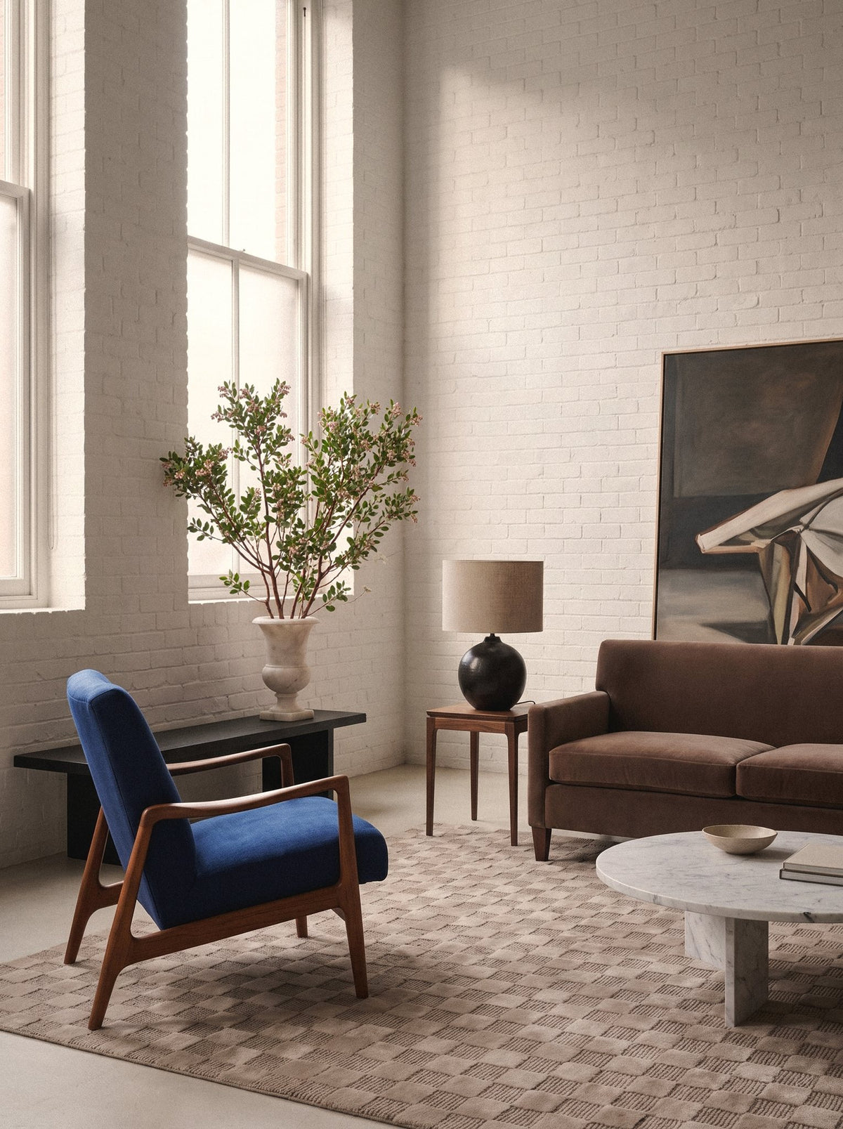Article 241 taupe checkerboard merino wool and cashmere hand-knotted rug in a loft living room