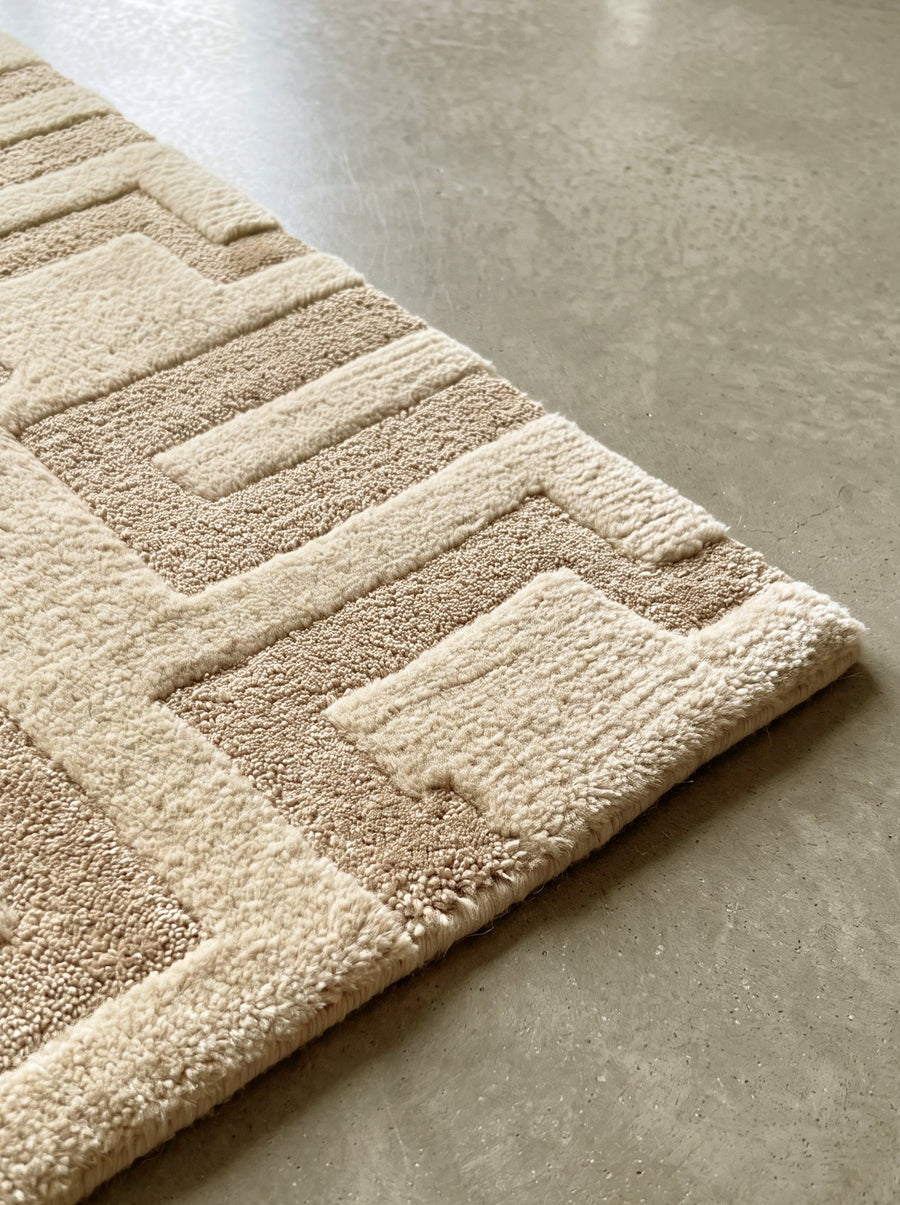 Corner of the Article 441 ivory carved mosaic alpaca and linen hand-knotted rug showing the pile and finished edge