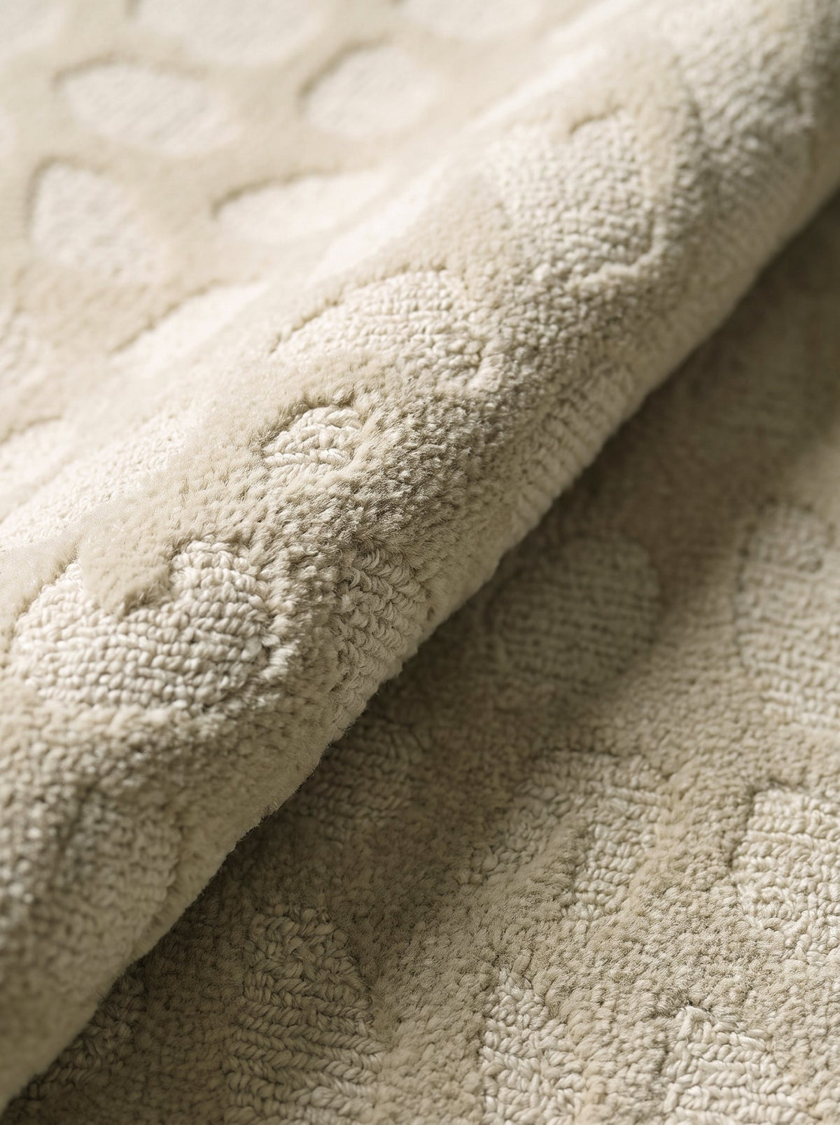 Article 442 ivory pebble alpaca hand-knotted rug folded back to show pile depth and texture