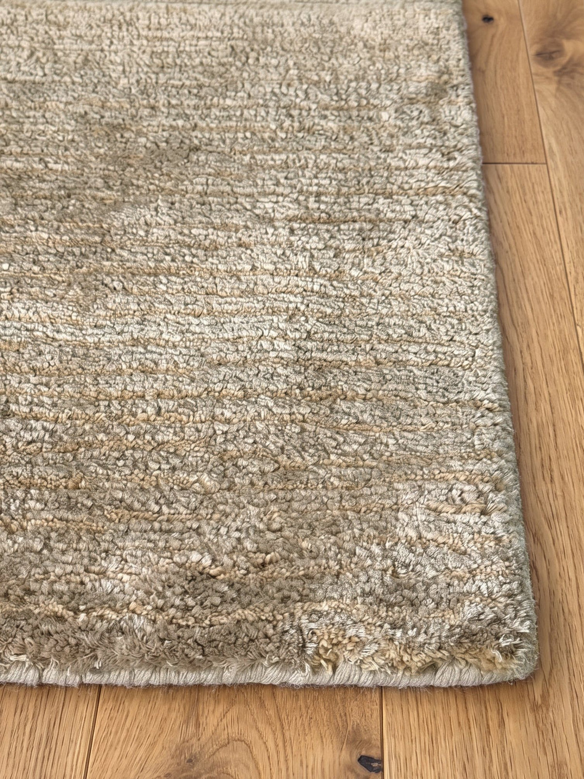 Corner of the Article 541 taupe heathered silk and linen hand-knotted rug showing the pile and finished edge