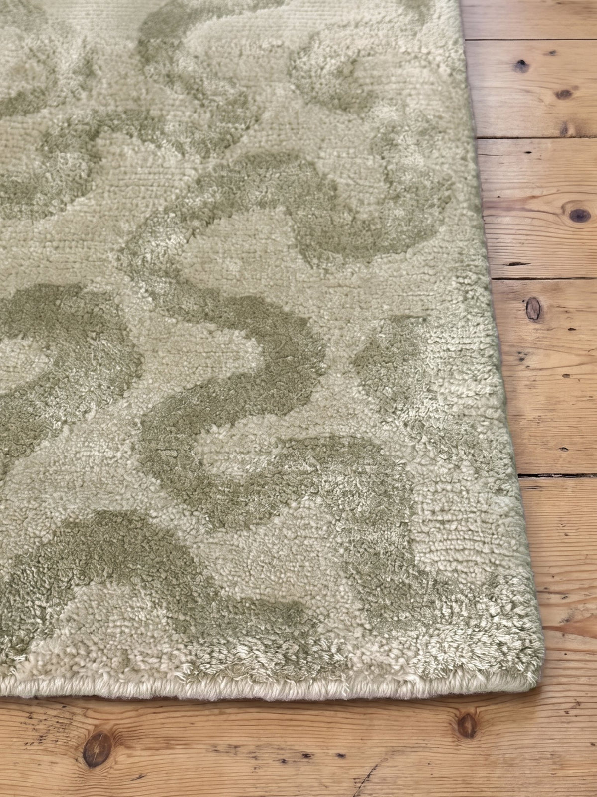 Corner of the Article 641 sage squiggle cashmere and silk hand-knotted rug showing the pile and finished edge